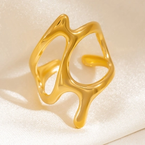 Irregular hollowed fluid design 18K gold plated stainless steel ring on white satin