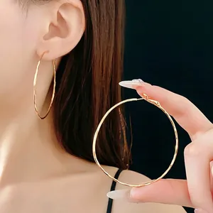 Grandi orecchini a cerchio dorati minimalisti da donna con un design circolare leggero