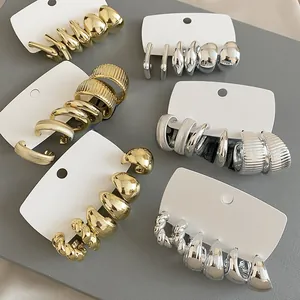 Macro view of gold and silver hoop earring set with smooth and twisted metal textures
