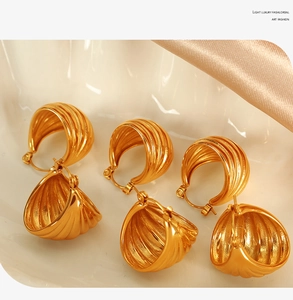 Detailed view of gold croissant hoop earrings with vintage texture on wavy display