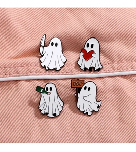 Detailed view of four ghost enamel pins with knife, heart, bottle and boo sign on pink fabric