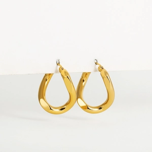 Detailed macro view of high-polished gold teardrop hoop earrings with twist design