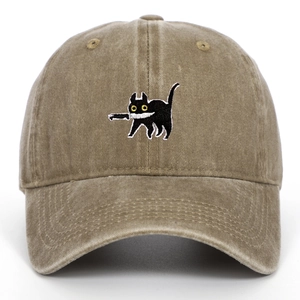 Close-up of cat biting a knife embroidery on a khaki vintage washed cotton baseball cap
