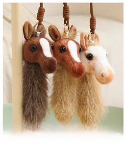 Detail of plush pony head keychains in three colors with soft faux fur and gold rings