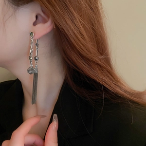 Vintage silver tassel earrings with green gemstones and long metallic fringes on model