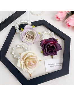 Detailed view of artificial rose hair ties with pearls in purple and white colors