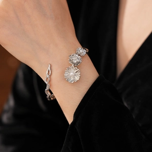 Detail of silver floral bangle with pearls and zircon on a vintage engraved metal cuff