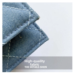 Close-up of diamond quilted denim fabric with white contrast stitching details