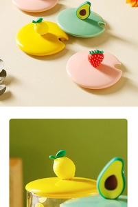Detail of colorful ceramic cup lids featuring cute lemon, avocado and strawberry handles