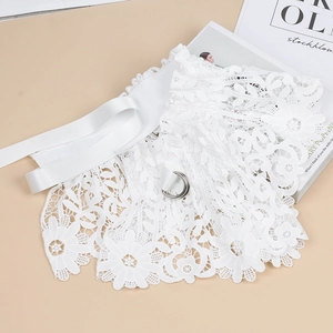 Detailed macro of white lace corset belt with intricate floral patterns and D-ring buckle