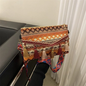 Close-up of bohemian woven crossbody bag with geometric patterns and colorful tassels