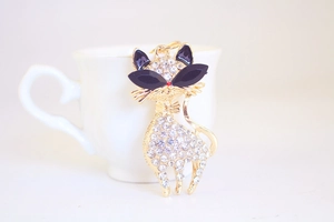 Macro view of crystal rhinestone cat keychain with black sunglasses on white background