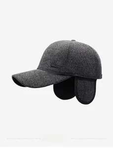 Macro side view of grey winter baseball cap with ear flaps and metal logo detail
