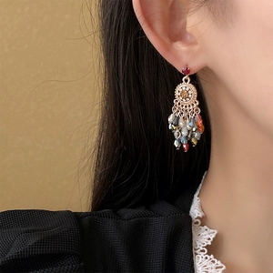 Detail view of retro flower crystal tassel earrings worn on person showing intricate craft