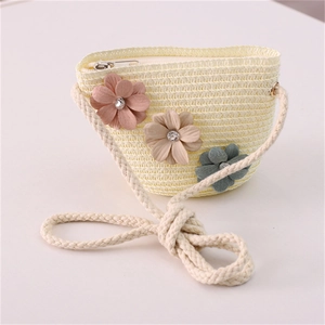 Detail of straw woven flower purse featuring a cotton rope strap and pastel floral accents