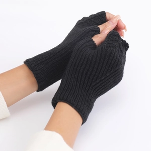 Detail of black knitted fingerless gloves with a textured fish-scale knit pattern