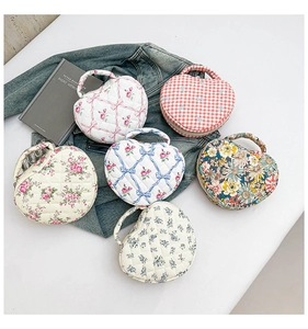 Detailed top view of six heart-shaped quilted makeup bags with diverse floral patterns