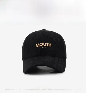 Detailed close-up of embroidered MOUTH letters on a black corduroy baseball cap