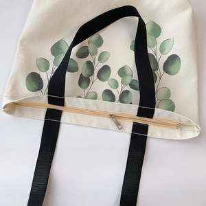 Detail view of canvas tote zipper closure and inner pocket with eucalyptus print