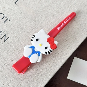 Nahaufnahme der roten Hello Kitty Acryl-Haarklammer mit Markenlogo auf Textilstoff