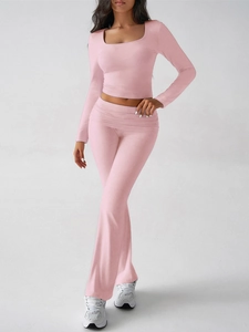 Détail du haut court rose à manches longues et du pantalon évasé à taille haute assorti