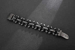Detail of punk style braided leather cord and vintage silver stainless steel link bracelet