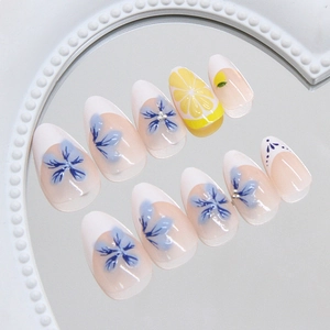 Short almond press-on nails with blue flowers, lemon patterns and pearls