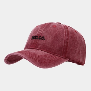 Close-up of vintage washed red baseball cap featuring detailed HELLO embroidery