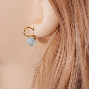 U-shaped stainless steel gold hook earrings with light blue cracked bead on model