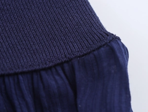 Detaillierte Nahaufnahme von dunkelblauem Rippstrick und plissiertem Textil-Patchwork