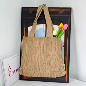 Detail of khaki knitted tote bag with Have a Nice Time pattern and tulip decoration