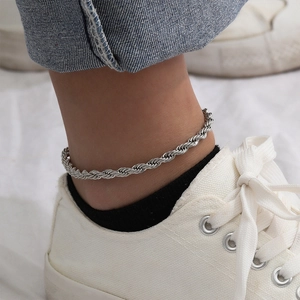 Detail shot of silver stainless steel twisted rope anklet on ankle with white shoe