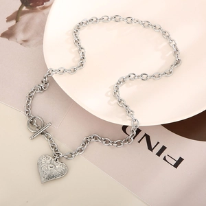Detail of silver chain necklace with hollow heart pendant and toggle clasp on magazine