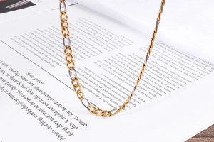 Close-up of gold and silver cuban link chain jewelry set on a magazine background
