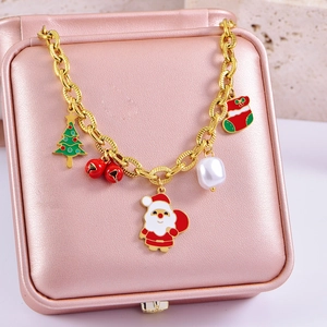 Festive gold Christmas charm bracelet with Santa, tree and pearl on a jewelry box