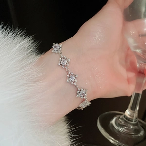 Close-up of silver-plated bracelet with cubic zirconia clusters on white faux fur cuff