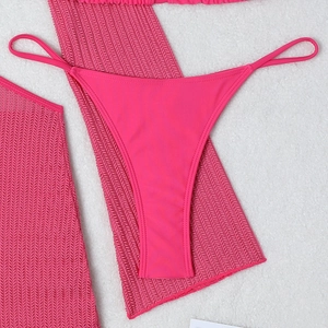 Flat lay detail of rose red mesh sarong and matching bikini bottoms for beachwear