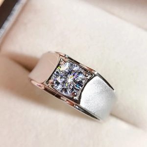 Close-up of men's silver ring with matte finish and brilliant round-cut clear gemstone