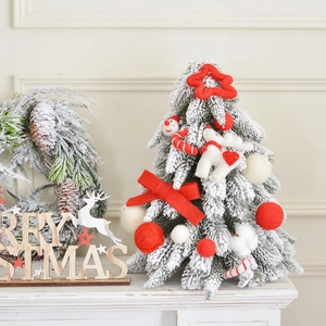 Miniature snow-covered Christmas tree with red and white felt ornaments for tabletop decor