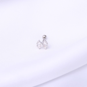 Close-up of a silver bow cartilage stud earring featuring clear cubic zirconia stones