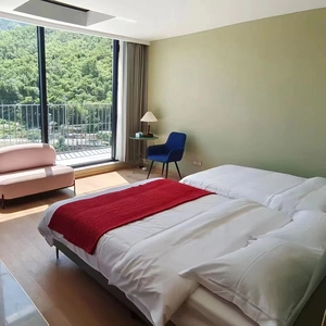 Bright modern hotel room featuring a luxury white cotton bathrobe set on a king-size bed