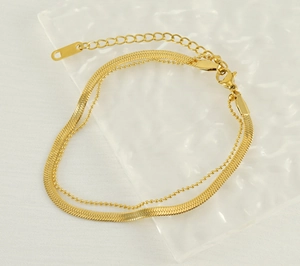 Details einer 18k vergoldeten zweilagigen Schlangenkette und Perlenkette mit Karabiner