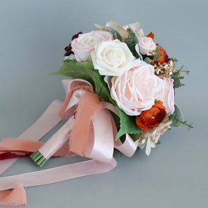 Wedding bridal bouquet with cream roses, champagne pink flowers, and long flowing ribbons