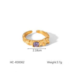 Macro detail of 18K gold hammered ring featuring a round purple gemstone inlay