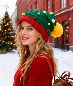 Feestelijke groen-rode gebreide kerstboommuts met kleurrijke pompons voor de winter
