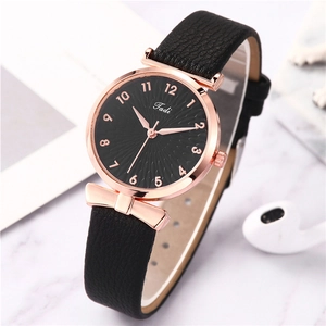 Detail of rose gold case and black dial on a textured leather strap watch
