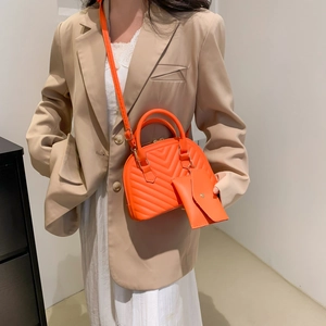Stepptasche in Hellorange mit Minitasche am Model, elegantes Schultertaschen-Zweiteiler
