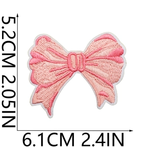 Detail view of pink bow embroidered patch with dimensions 6.1cm width and 5.2cm height