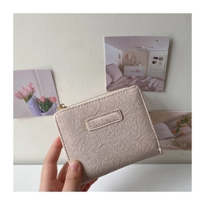 Detail shot of beige pleated leather coin purse with zipper and vintage textured finish