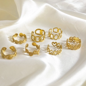 Set of 7 gold titanium steel open rings featuring daisy, geometric, and heart designs
